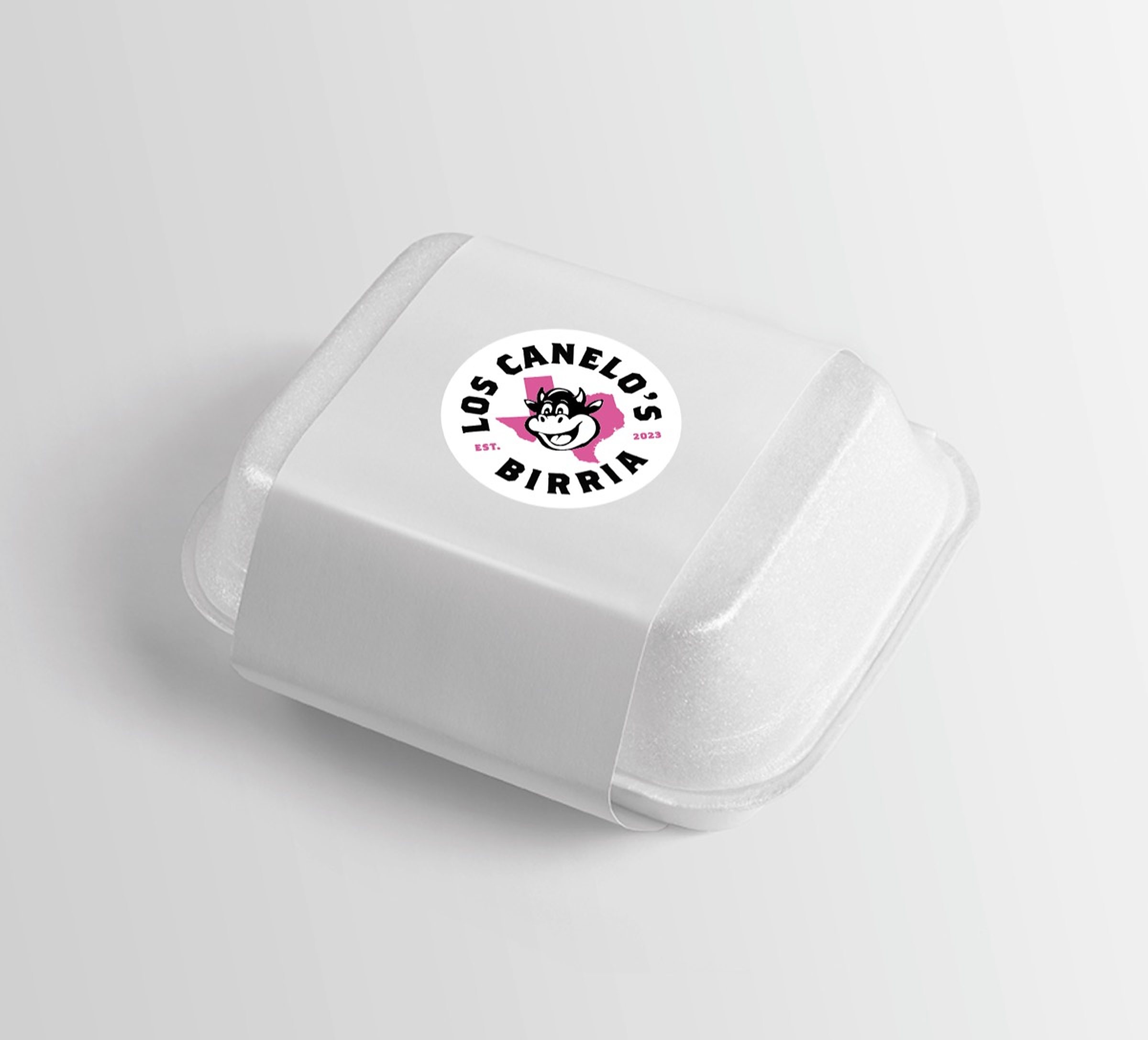 The same takeout container carrying the cartoon cow version of the round label.